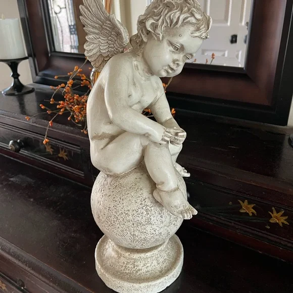 Resin angel statue on a ball 14 1/2 tall 8” wide cream colored